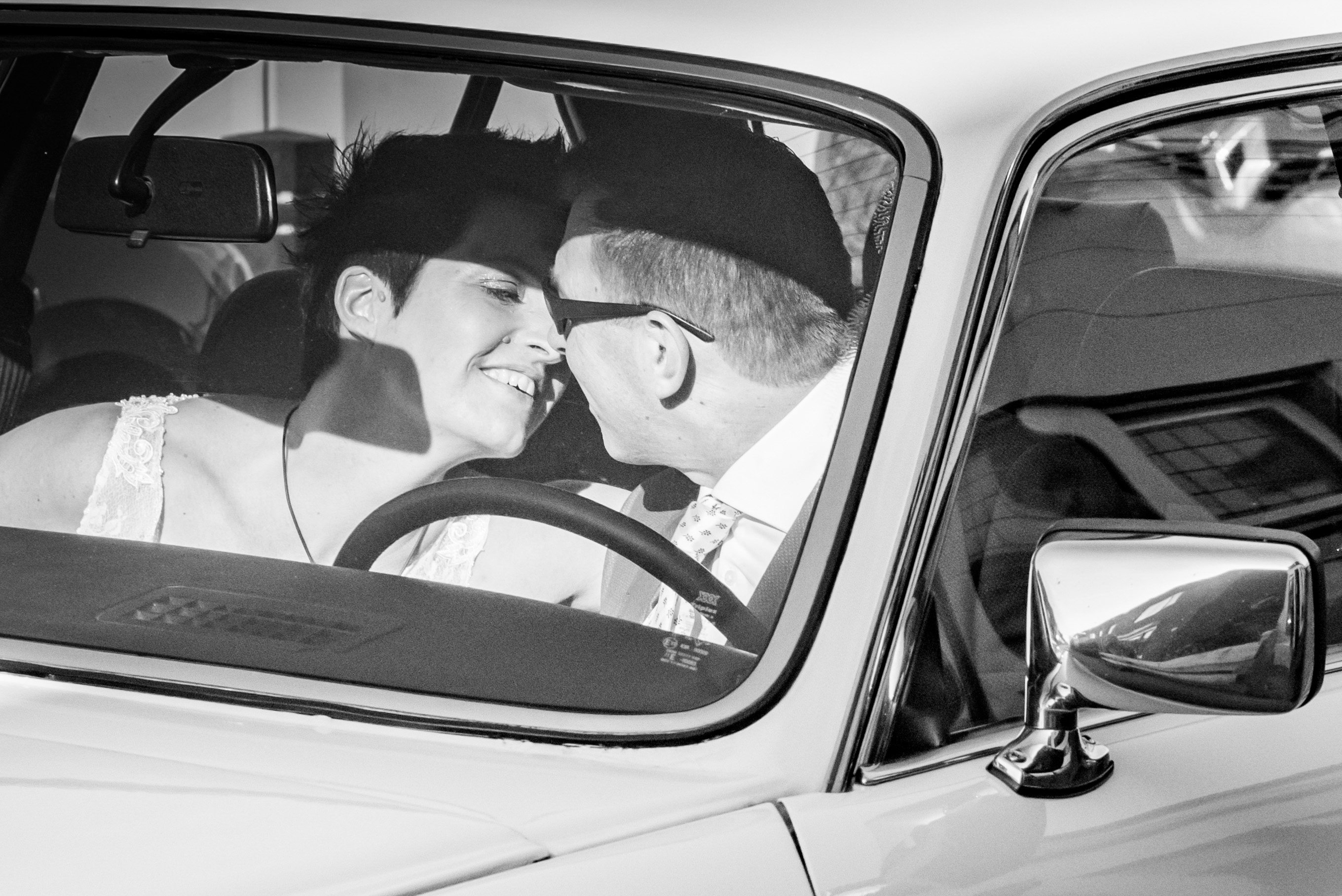 Bruid en bruidegom kussen in auto