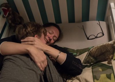 Moeder knuffelt haar zoon tijdens het naar bed brengen Jasja de Wit Fotografie