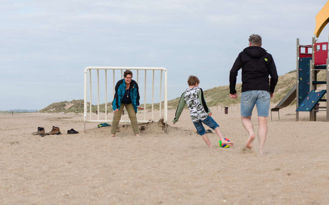 Moeder heeft plezier met haar gezin tijdens het voetballen.