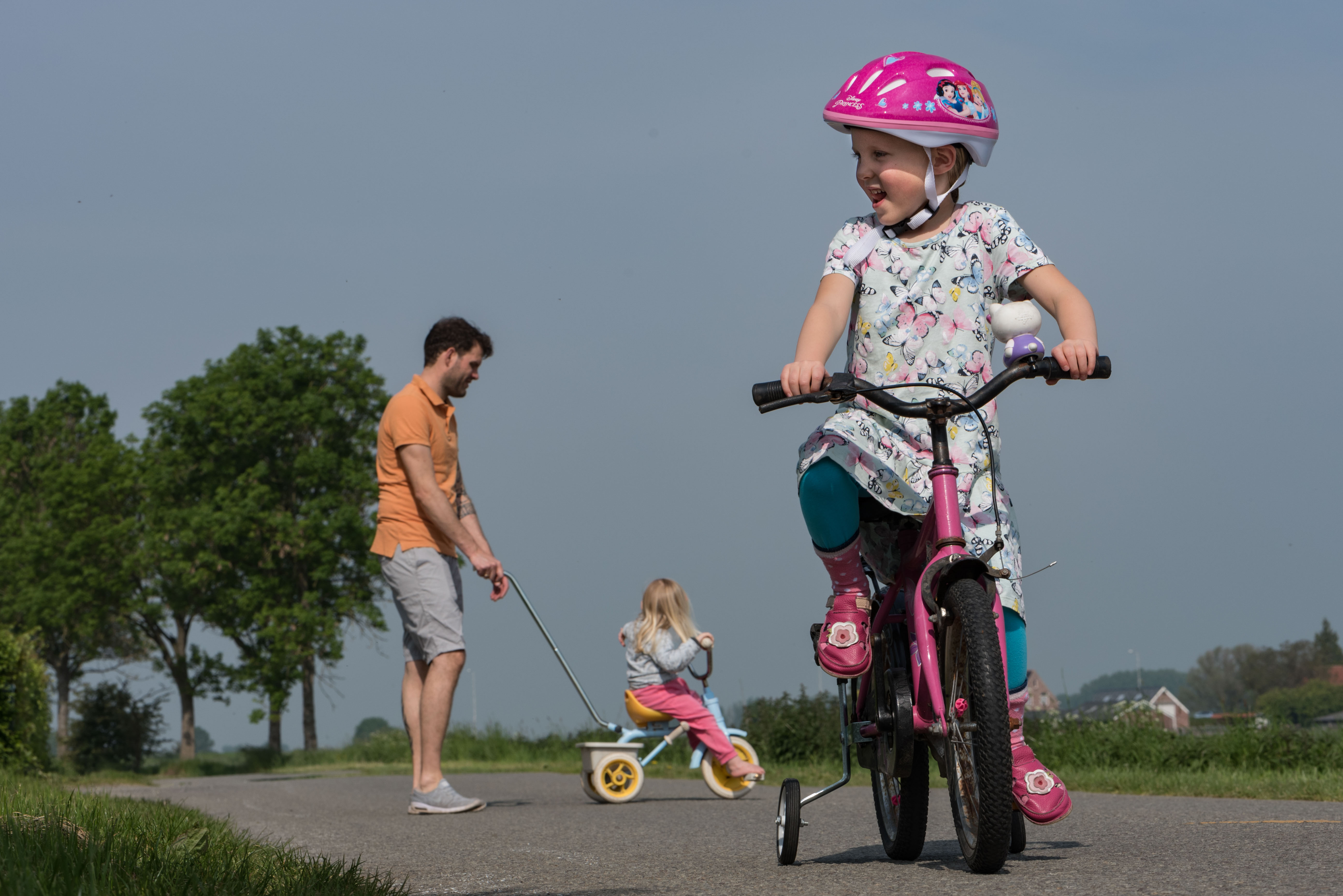 Meisje fietst op fiets met zijwieltjes Jasja de Wit Fotografie