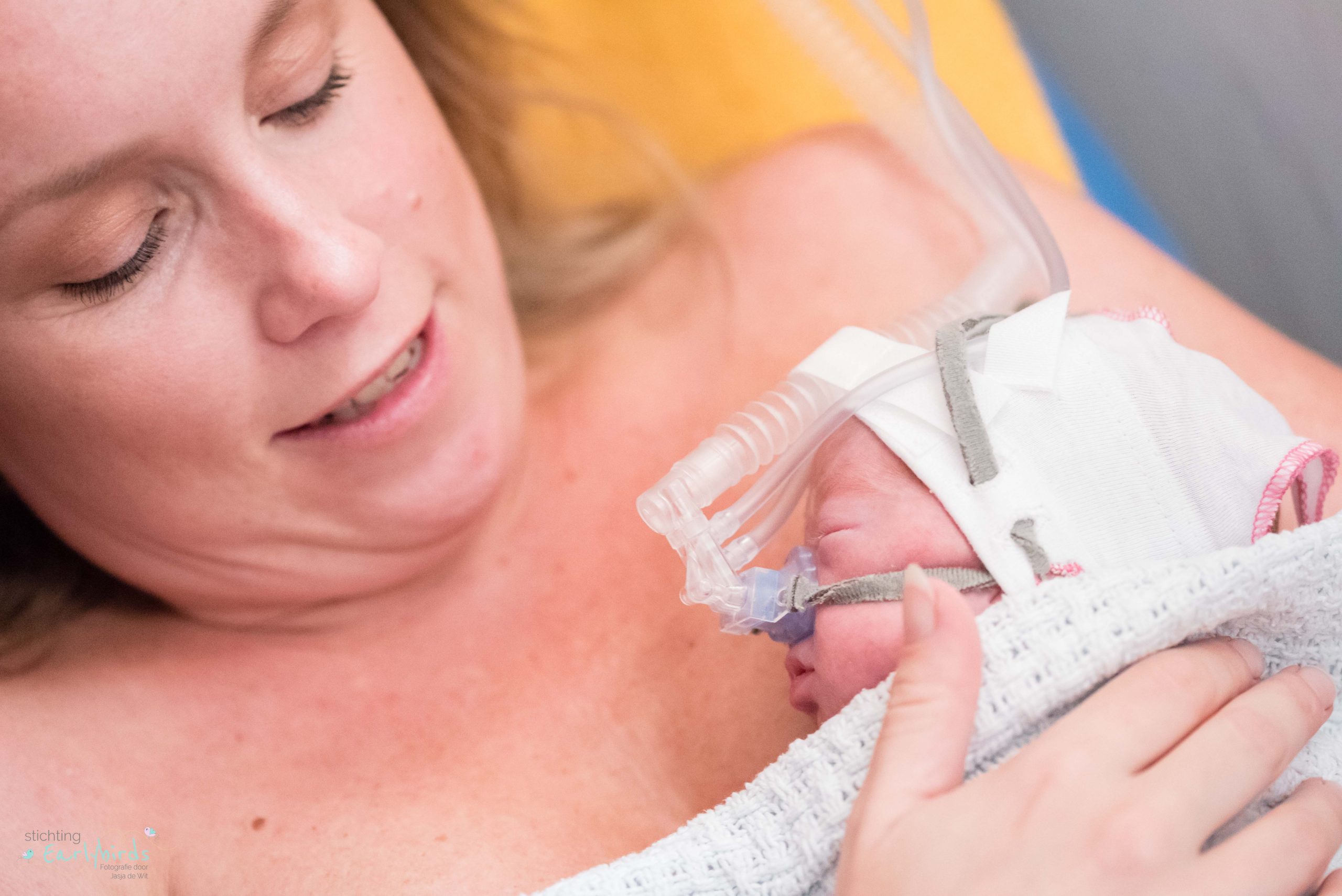 Moeder buidelt met baby met CPAP