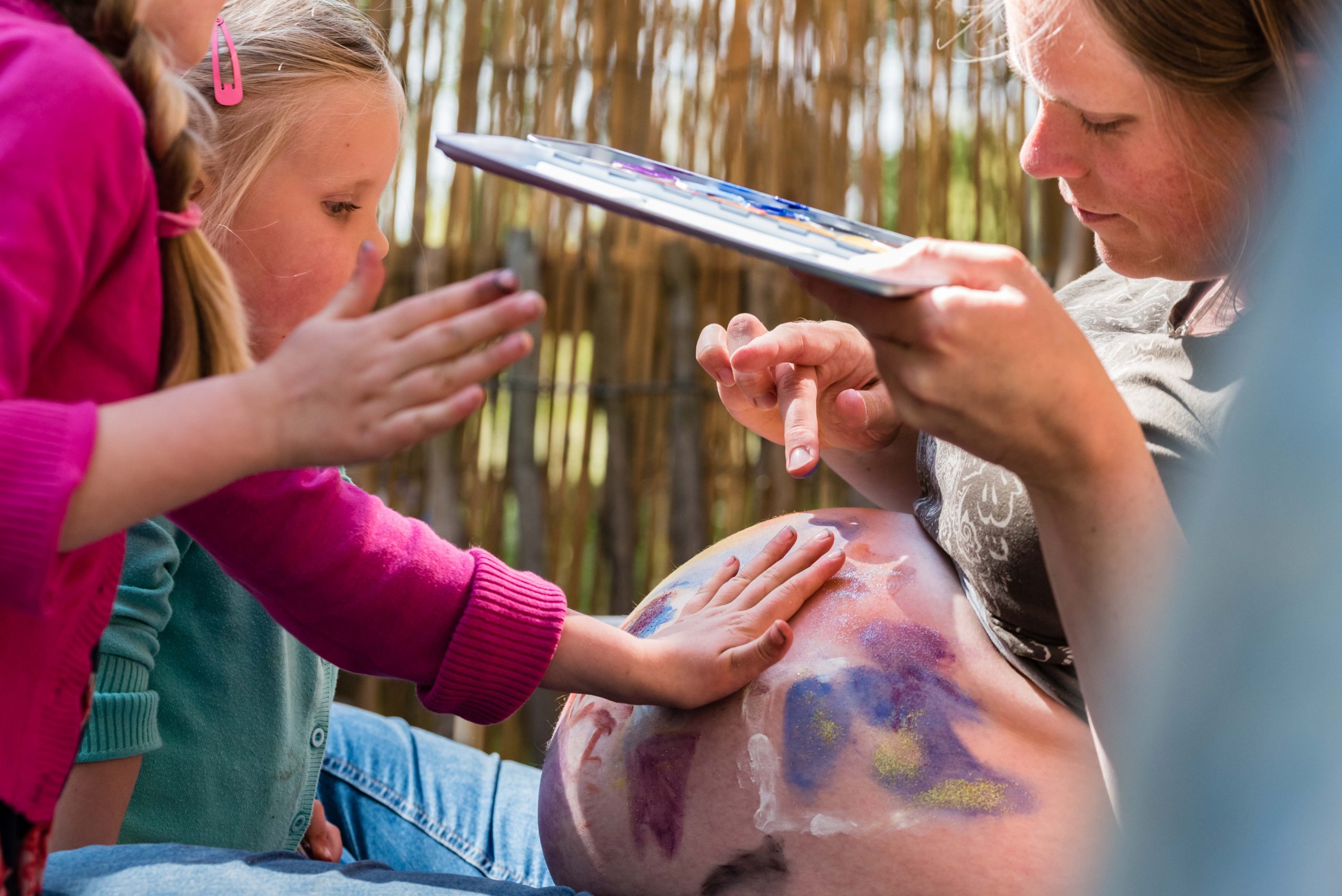 Kinderen beschilderen de buik van hun zwangere moeder Jasja de Wit Fotografie