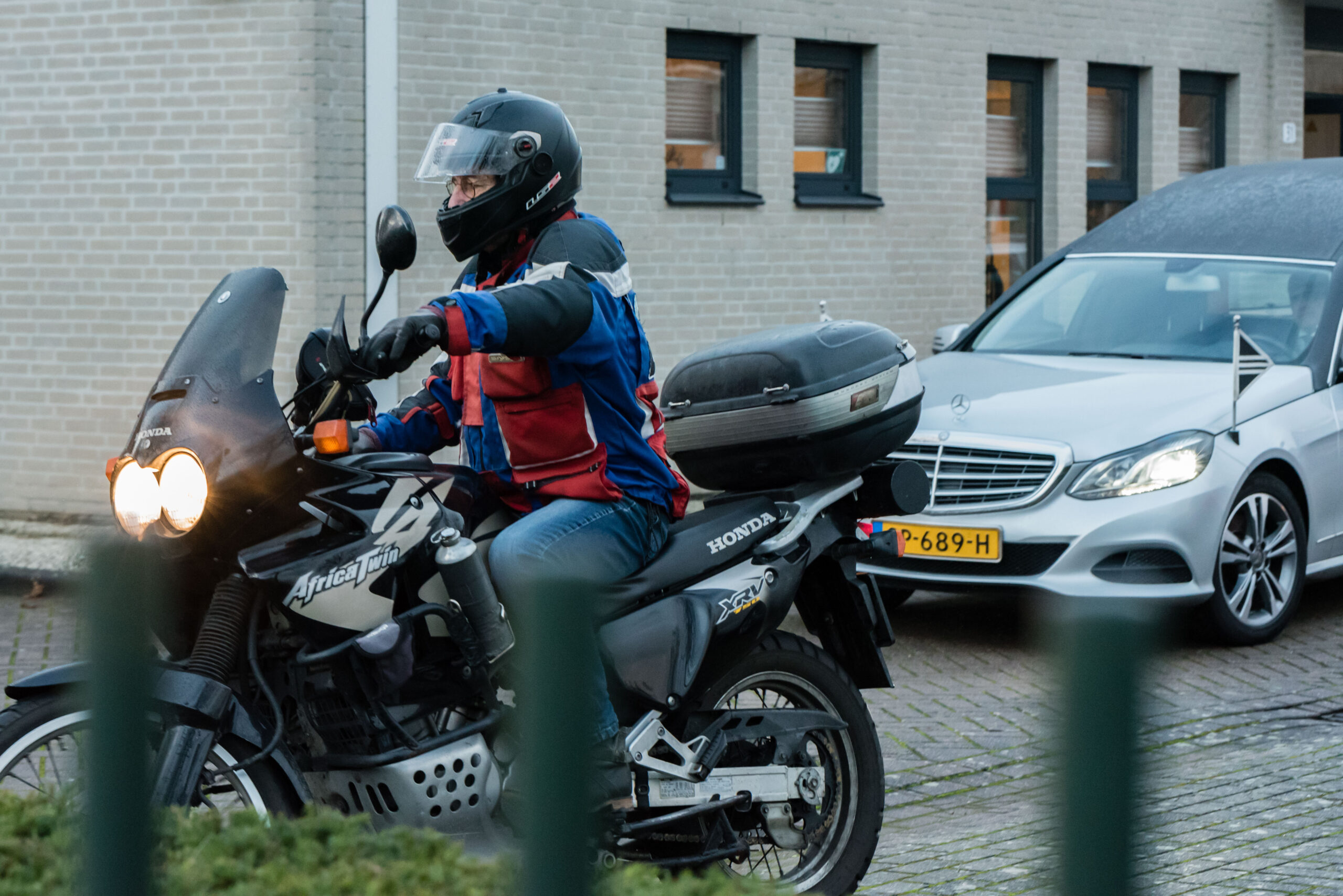 Een vriend van Hans rijdt op zijn moor voor de rouwauto uit