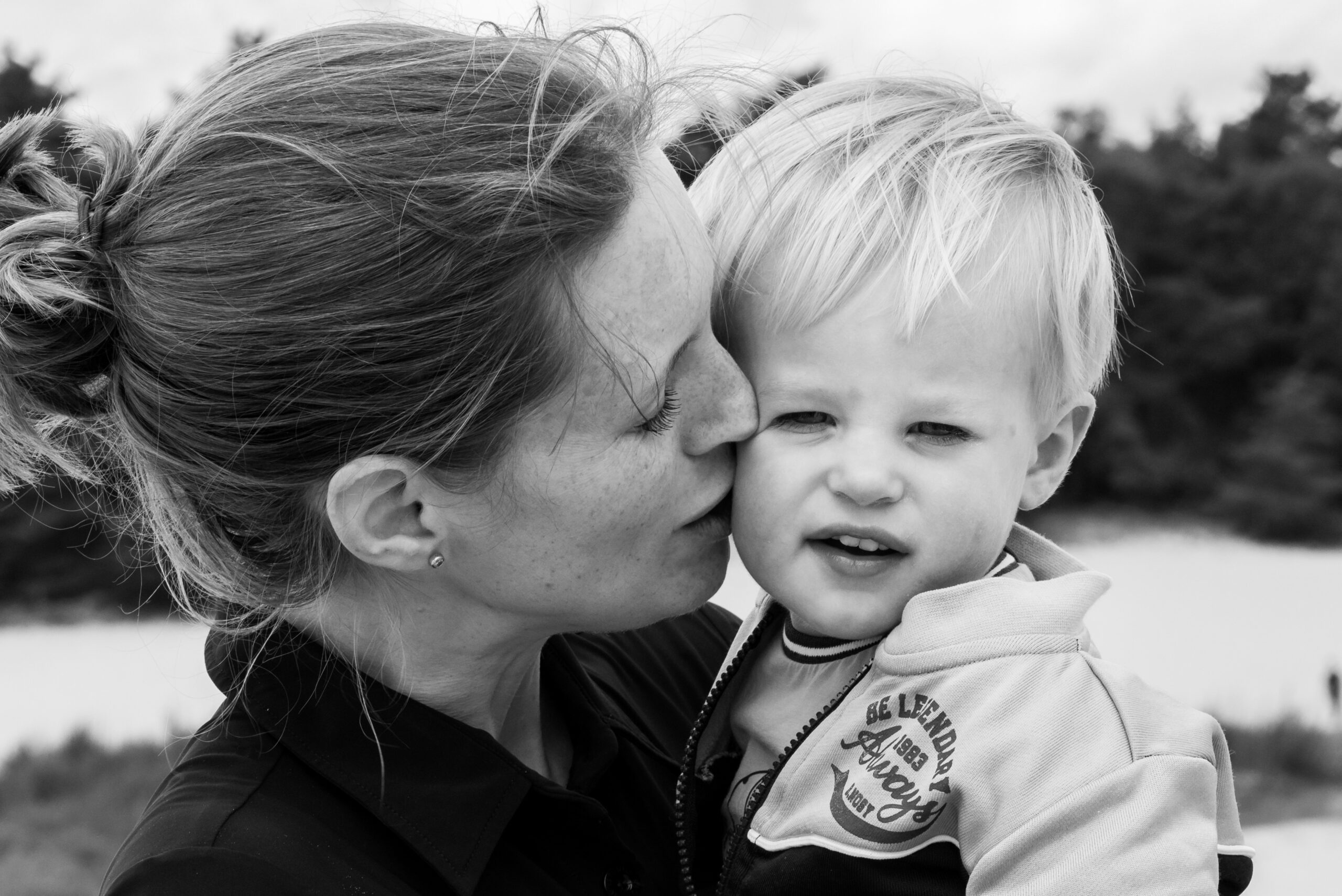 Spontane foto van knuffel tussen moeder en zoon tijdens fotoshoot Moeder knuffelt haar zoon Jasja de Wit Fotografie Herinneringsfotografie
